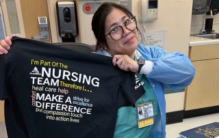 Nurse smiling holding shirt