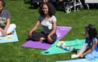 Two adults and child sitting for yoga lesson