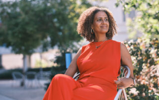 In this image from the Get Screened for Life campaign, a woman in orange clothes sits in a chair outdoors